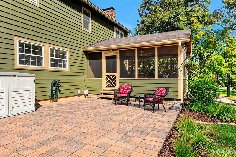 Paver patio featuring a screened-in porch with wood-finish siding, multi-pane windows, and a lattice-detail screen door — 15552 Chequer Drive, Chesterfield, MO 63017