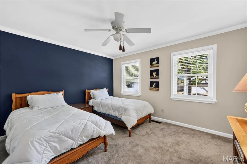 Neutral-toned carpeting, dual windows with white casing, and a ceiling-mounted light fixture with a multi-blade fan — 15552 Chequer Drive, Chesterfield, MO 63017