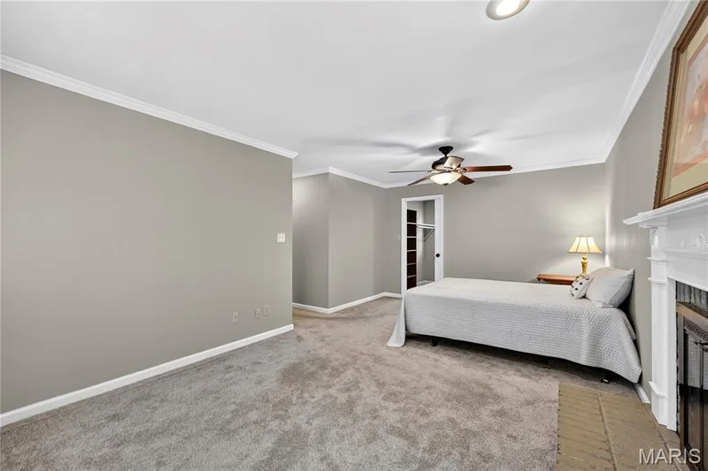 Neutral-toned room featuring a white-mantel fireplace, recessed lighting, crown molding, and a ceiling fan — 15552 Chequer Drive, Chesterfield, MO 63017