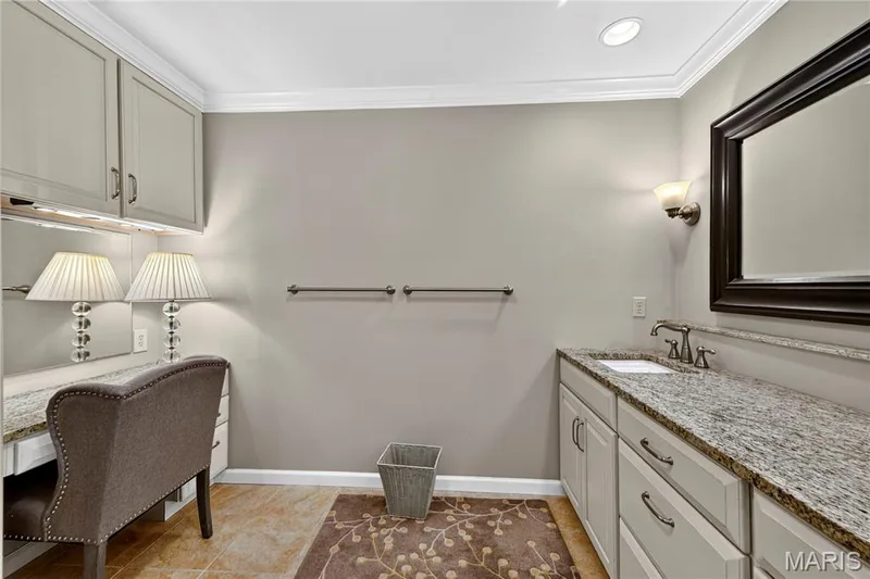 Built-in vanity station with upper cabinetry, stone-finish countertops, undermount sink, and recessed lighting — 15552 Chequer Drive, Chesterfield, MO 63017