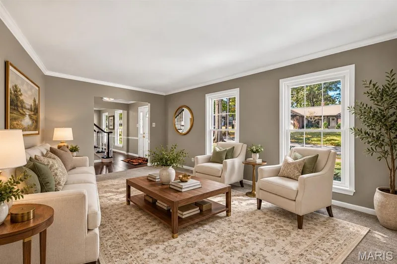 Living area featuring crown molding, neutral wall tones, and double-hung windows with exterior trim — 15552 Chequer Drive, Chesterfield, MO 63017