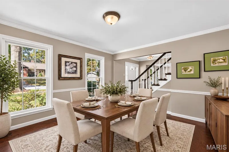 Dining area featuring crown molding, chair rail trim, multi-pane windows, and wood-finish flooring — 15552 Chequer Drive, Chesterfield, MO 63017