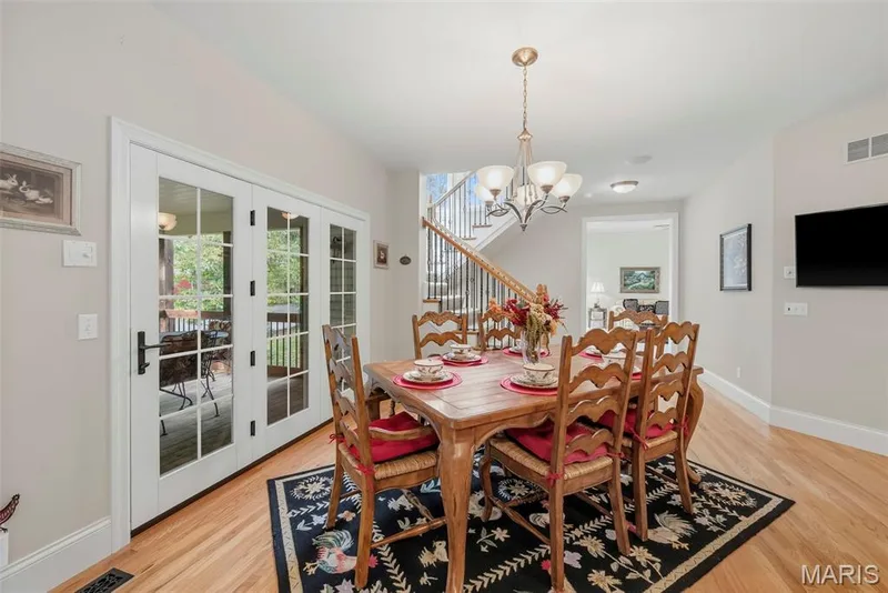 Breakfast Room featuring wood-finish flooring, a multi-arm chandelier, and double French doors with glass panes — 112 Castlewood Estates Drive, O'Fallon, MO 63368