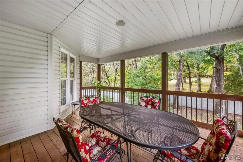 Covered Deck featuring wood decking, beadboard ceiling, wooden support posts, and metal balusters — 112 Castlewood Estates Drive, O'Fallon, MO 63368