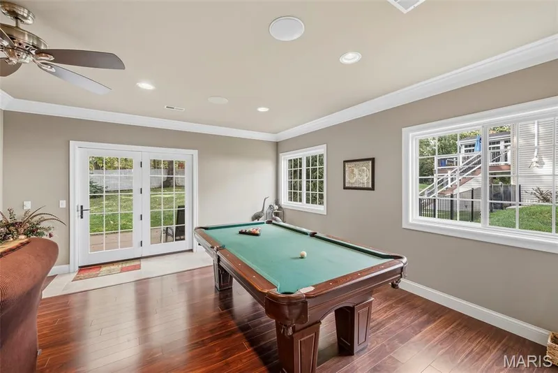Wood-finish flooring, crown molding, recessed lighting, ceiling fan, and French doors featuring glass panes — 112 Castlewood Estates Drive, O'Fallon, MO 63368