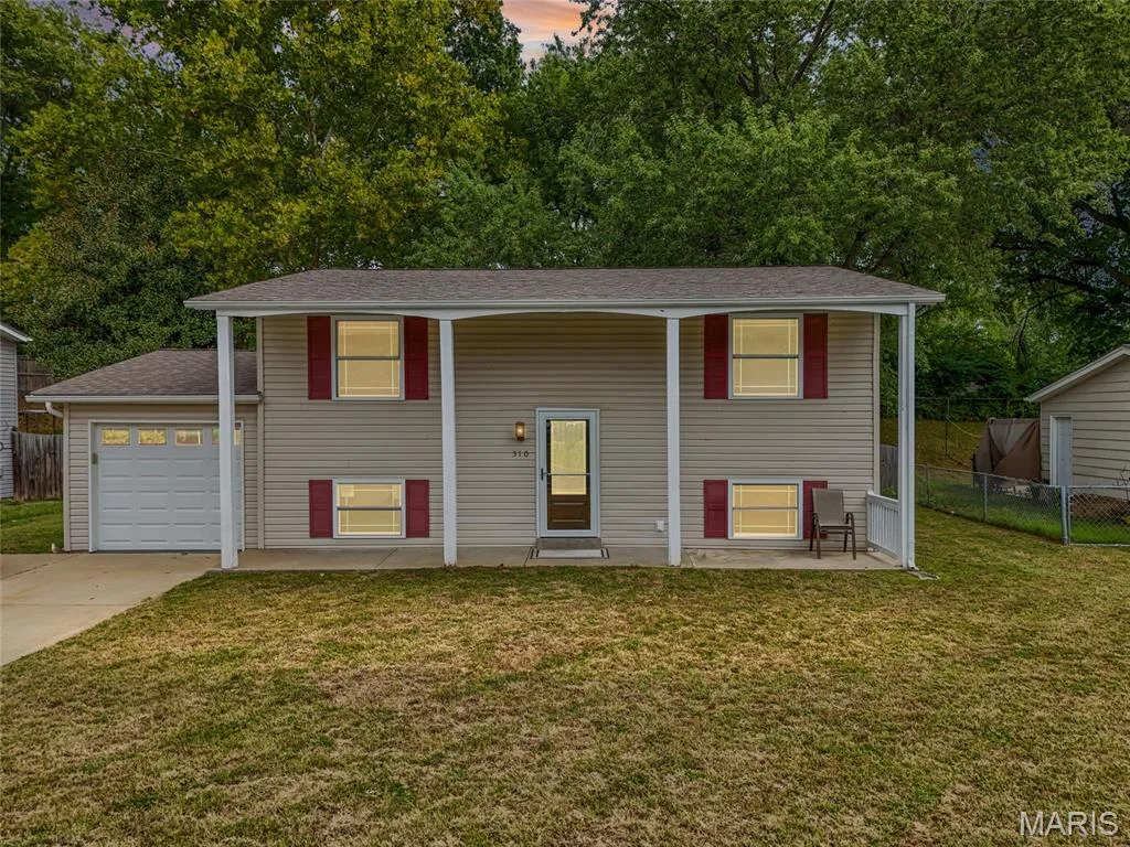 Split-foyer home on a 0.175-acre lot in the Francis Howell R-III school district. Dusk sky digitally enhanced. — 510 Keeney Drive, St Charles, MO 63304