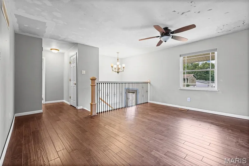 Main-level living room with wood-look plank flooring, ceiling fan and replacement windows (about 2021). — 510 Keeney Drive, St Charles, MO 63304