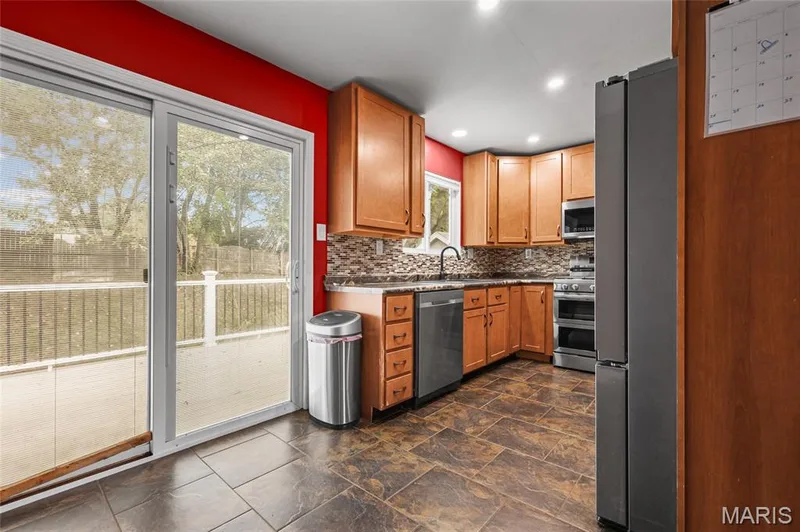 Dining area slider opens straight onto the deck, with the updated kitchen beside it. — 510 Keeney Drive, St Charles, MO 63304