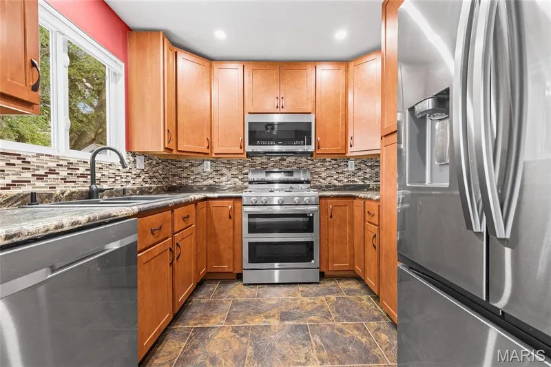 Wood cabinets, mosaic tile backsplash and tile floor. — 510 Keeney Drive, St Charles, MO 63304