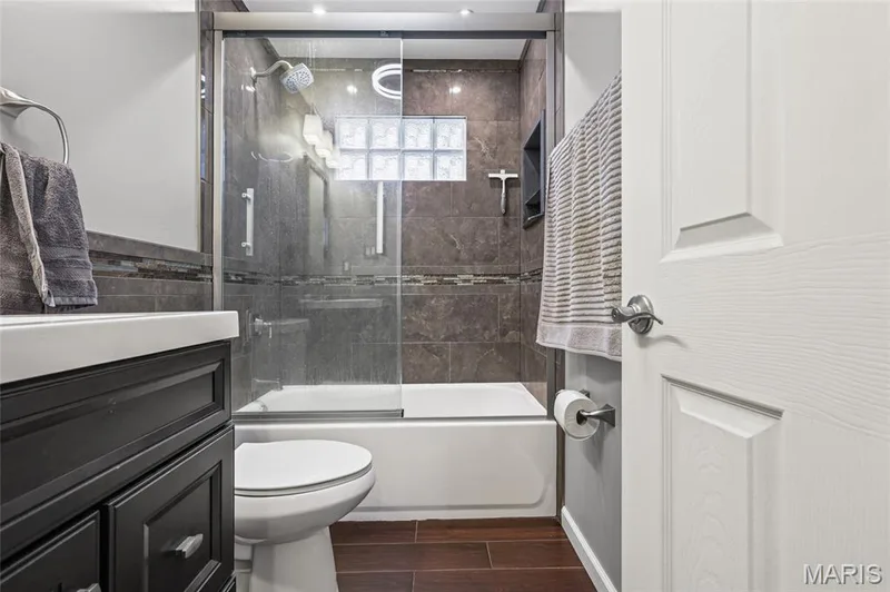 Updated main-level full bath with tiled tub surround and glass doors. — 510 Keeney Drive, St Charles, MO 63304