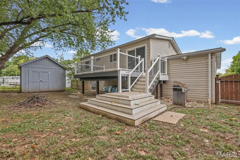 Composite deck stairs down to the fenced back yard and storage shed. — 510 Keeney Drive, St Charles, MO 63304