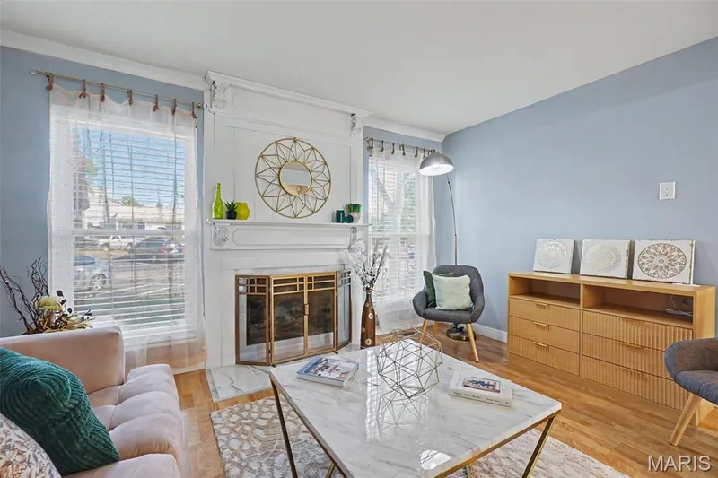 Elegant fireplace with a decorative mantel and brass-toned screen — 81 Schooner Lane #1, Lake St. Louis, MO 63367