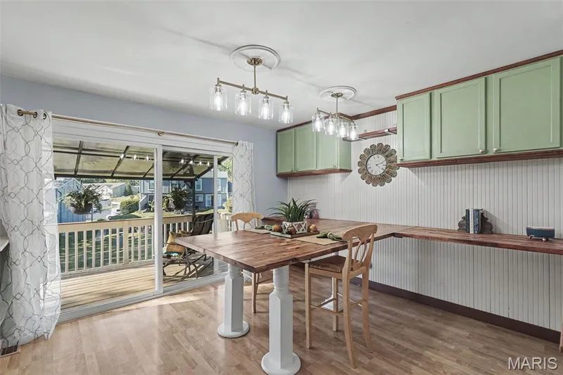 Wood-finish flooring, sliding glass door, overhead lighting fixtures, built-in shelving, and upper cabinetry — 81 Schooner Lane #1, Lake St. Louis, MO 63367