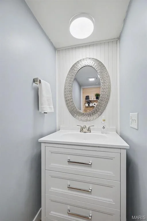 White vanity with three drawers and polished chrome pulls, integrated sink, and white countertop — 81 Schooner Lane #1, Lake St. Louis, MO 63367