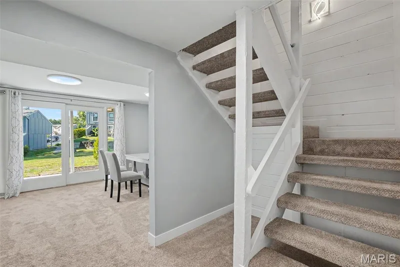 Carpeted staircase with white painted railing, white shiplap wall detail, and flush-mount ceiling light — 81 Schooner Lane #1, Lake St. Louis, MO 63367