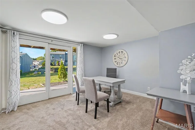 Sliding glass doors opening to the exterior, light gray wall paint, recessed ceiling lighting, and carpeted flooring — 81 Schooner Lane #1, Lake St. Louis, MO 63367