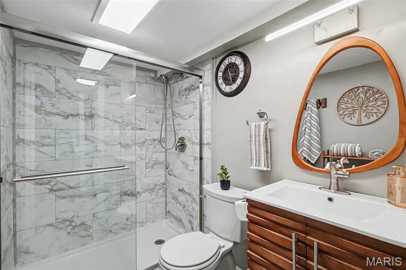 Enclosed shower with marble-look tile surround and glass door — 81 Schooner Lane #1, Lake St. Louis, MO 63367