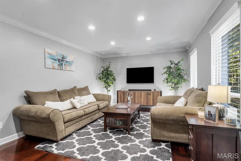 Living area featuring dark wood-finish flooring, crown molding, recessed lighting, and horizontal window blinds — 1444 Eagle Ridge Road, Wildwood, MO 63038