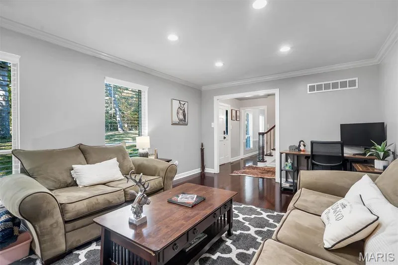Spacious interior featuring dark wood-finish flooring, crown molding, and recessed lighting — 1444 Eagle Ridge Road, Wildwood, MO 63038