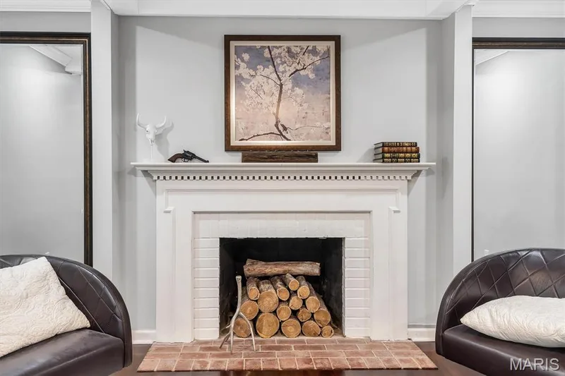 Fireplace featuring a white painted brick surround, classic dental molding mantel, and a red brick hearth — 1444 Eagle Ridge Road, Wildwood, MO 63038