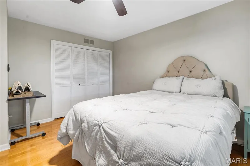 Neutral wall tones, wood-finish flooring, and white louvered-door closet featuring overhead ceiling fan fixture — 1444 Eagle Ridge Road, Wildwood, MO 63038
