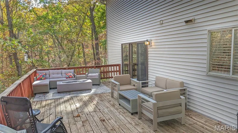 Elevated wood deck featuring horizontal railing, exterior wall-mounted lighting, and siding exterior — 1444 Eagle Ridge Road, Wildwood, MO 63038