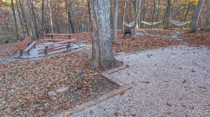 Wooded lot featuring a gravel surface, brick edging, stone path, and a circular fire pit area — 1444 Eagle Ridge Road, Wildwood, MO 63038