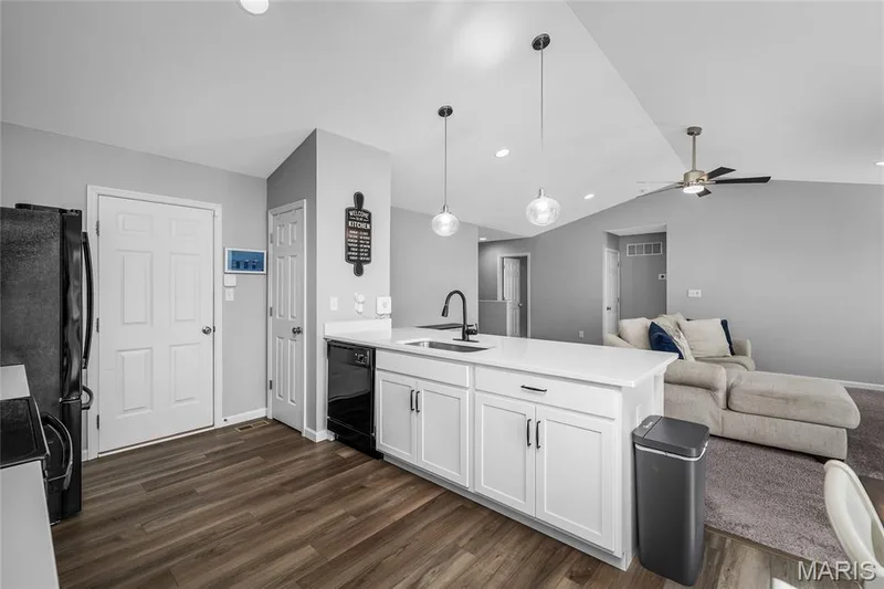 Kitchen island with white cabinetry, a black faucet, and pendant lighting — 302 Creek Sound Court, Wentzville, MO 63385
