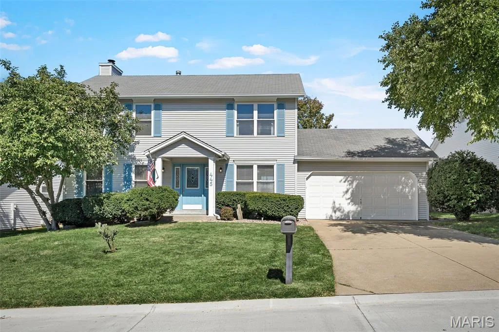Two-story residence with siding exterior, attached two-car garage, covered entry porch, and concrete driveway — 445 Lantana Lane, St Peters, MO 63376