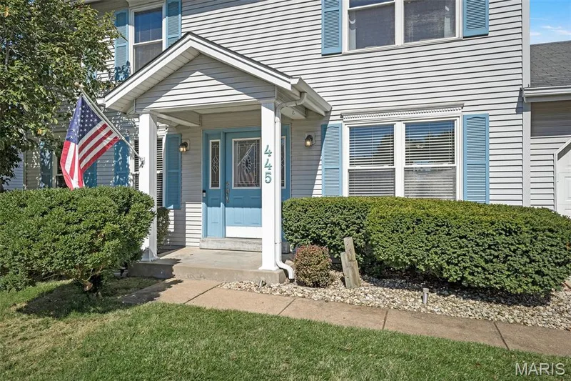 Covered front entry with white columns and light blue door — 445 Lantana Lane, St Peters, MO 63376