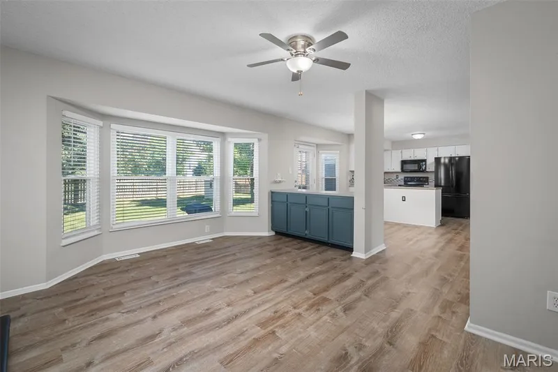 Bay window with extensive natural light, ceiling fan, and built-in cabinetry — 445 Lantana Lane, St Peters, MO 63376