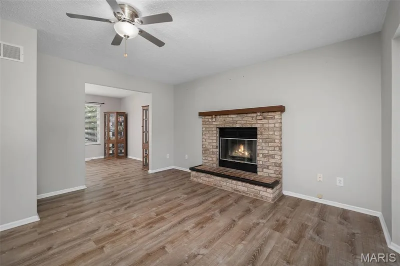 Brick fireplace with hearth and wood mantel — 445 Lantana Lane, St Peters, MO 63376