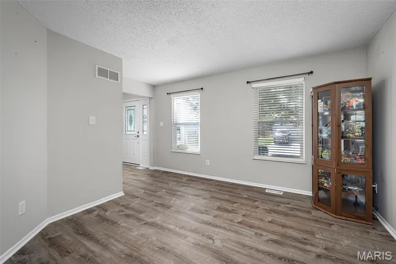 Light gray wall paint, multiple windows, white window blinds, and a decorative front entry door — 445 Lantana Lane, St Peters, MO 63376
