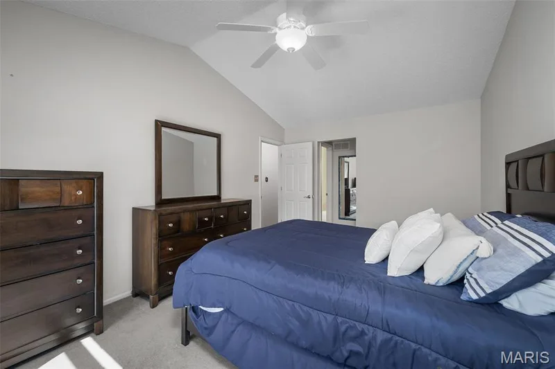 Vaulted ceiling with a ceiling fan, light gray wall paint, and gray carpeting — 445 Lantana Lane, St Peters, MO 63376