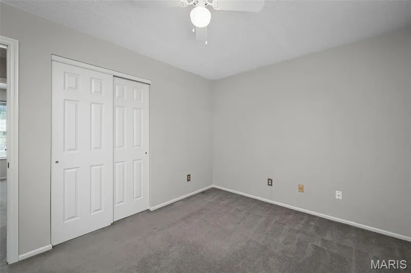 Plush gray carpeting, light gray wall finishes, white trim, and a ceiling fan with integrated lighting — 445 Lantana Lane, St Peters, MO 63376