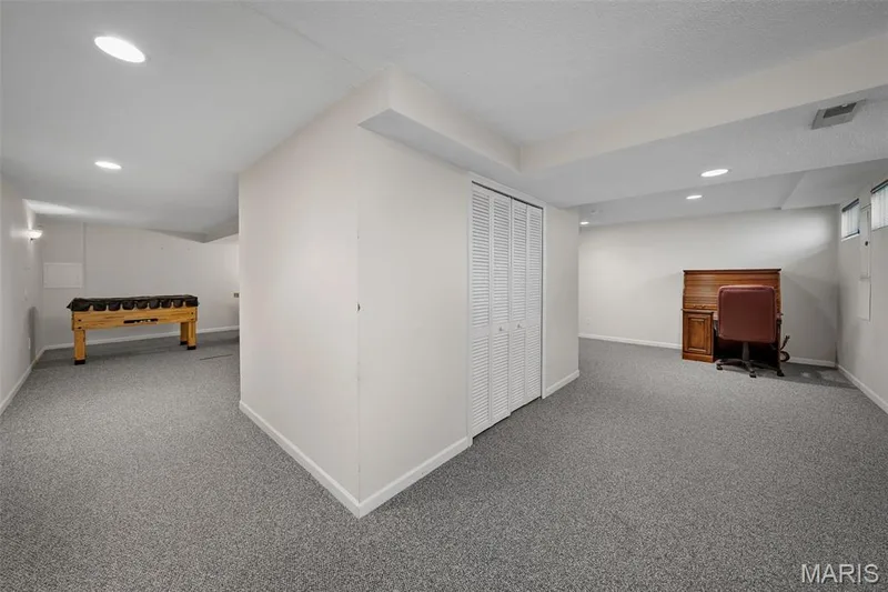 Spacious carpeted area with recessed lighting, white walls, and louvered closet doors — 445 Lantana Lane, St Peters, MO 63376