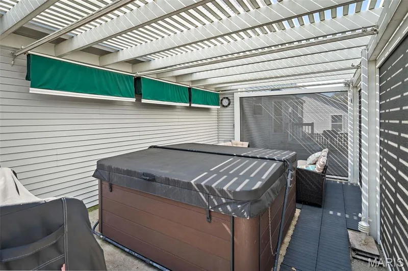 Attached pergola with slatted roof, privacy screen, and multiple green retractable awnings — 445 Lantana Lane, St Peters, MO 63376