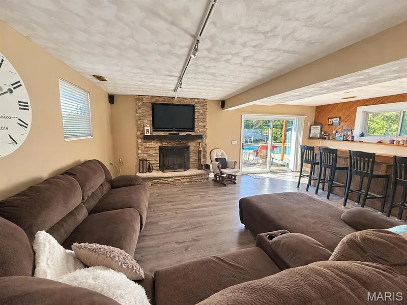 Built in surround sound, custom stacked stone surround on the woodburning fireplace, walk out to the amazing pool oasis — 111 Valvero Drive, St Charles, MO 63304