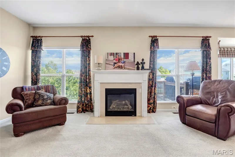 Gas fireplace featuring a white mantel, stone-finish hearth, and double windows — 2061 Avalon Mist Circle, Dardenne Prairie, MO 63368