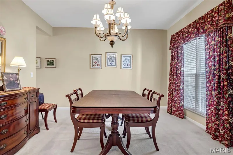 Multi-arm ornate chandelier, expansive window with horizontal blinds, and neutral wall tones — 2061 Avalon Mist Circle, Dardenne Prairie, MO 63368