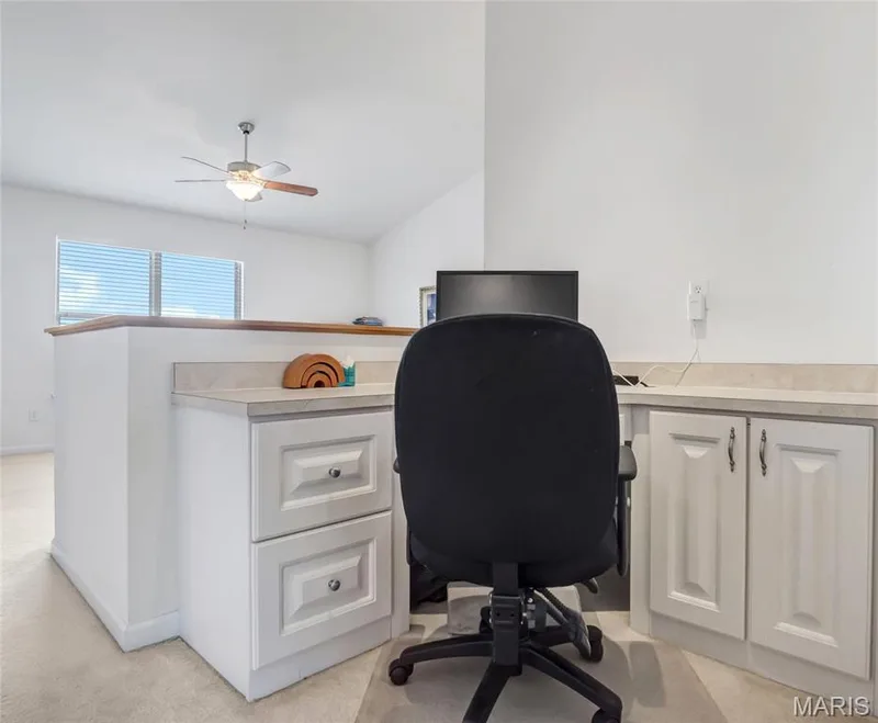 Built-in workstation featuring white cabinetry, stone-finish countertops, and a ceiling-mounted light fixture with integrated fan — 2061 Avalon Mist Circle, Dardenne Prairie, MO 63368