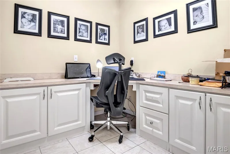 Built-in white cabinetry featuring shaker-style door fronts, solid-surface countertops, integrated drawer storage, and tile flooring — 2061 Avalon Mist Circle, Dardenne Prairie, MO 63368