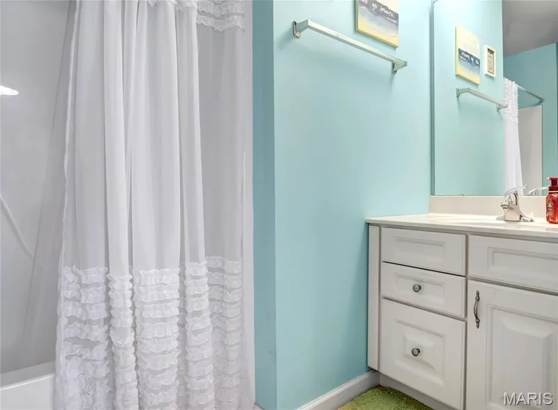 White vanity with recessed-panel cabinetry, integrated countertop with sink, chrome faucet, and wall-mounted chrome towel bar — 2061 Avalon Mist Circle, Dardenne Prairie, MO 63368