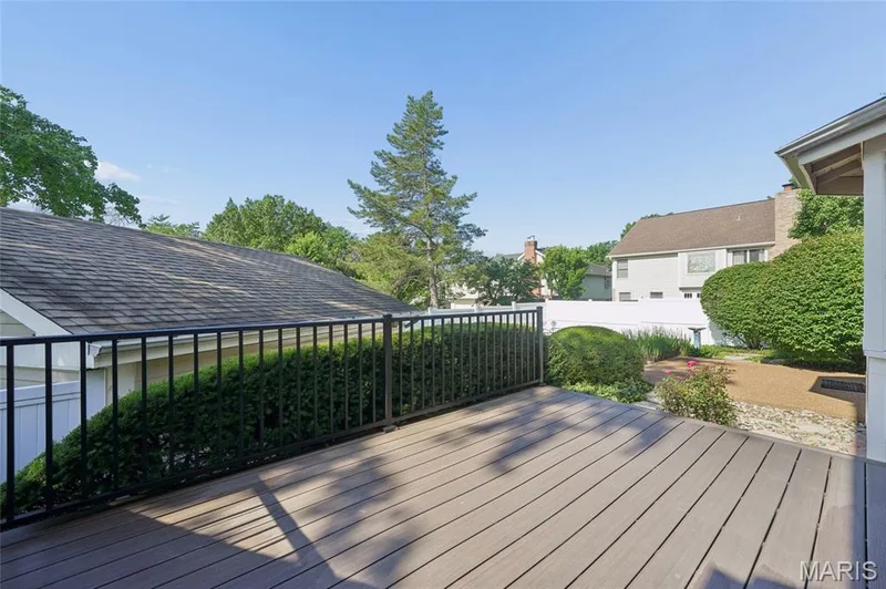 Expansive outdoor deck featuring wood-finish composite decking and a black metal railing — 15826 Harris Ridge Court #15826, Chesterfield, MO 63017