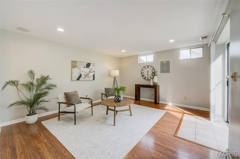 Wood-finish flooring, recessed lighting, ceiling-mounted speakers, multiple windows, and a tiled entry — 1094 Harness Drive, St Charles, MO 63304