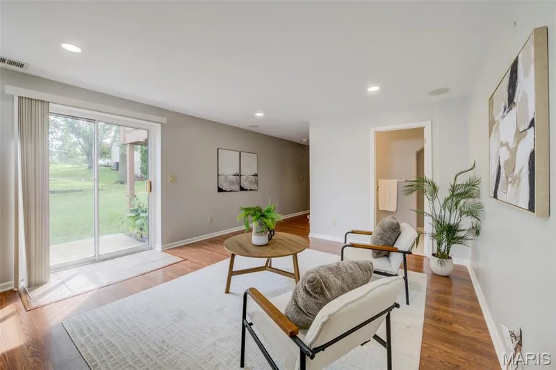 Sliding glass door to exterior, recessed lighting, wood-finish flooring, and a neutral color palette — 1094 Harness Drive, St Charles, MO 63304
