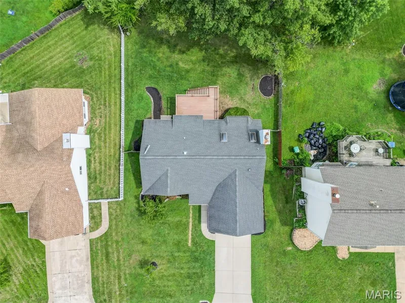 Expansive backyard featuring a manicured lawn, established trees, and a multi-level wood deck — 1094 Harness Drive, St Charles, MO 63304