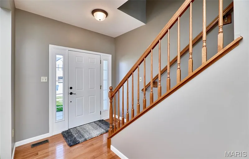 Entry Foyer features dual sidelights, gleaming hardwood and spindle staircase — 7428 Heathermoor Lane, Dardenne Prairie, MO 63368