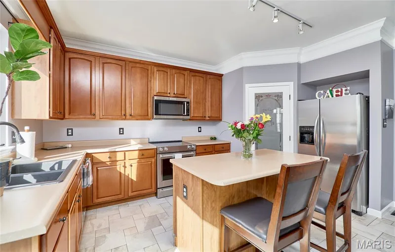Kitchen offers a central island with storage and breakfast bar — 7428 Heathermoor Lane, Dardenne Prairie, MO 63368