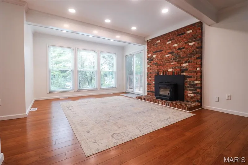 Fireplace in family room with large window that views back yard — 2502 Forest Leaf Parkway, Wildwood, MO 63011